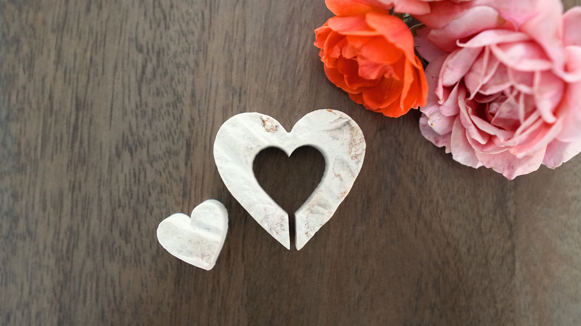 Two piece heart made from Jerusalem Stone next to vase of roses