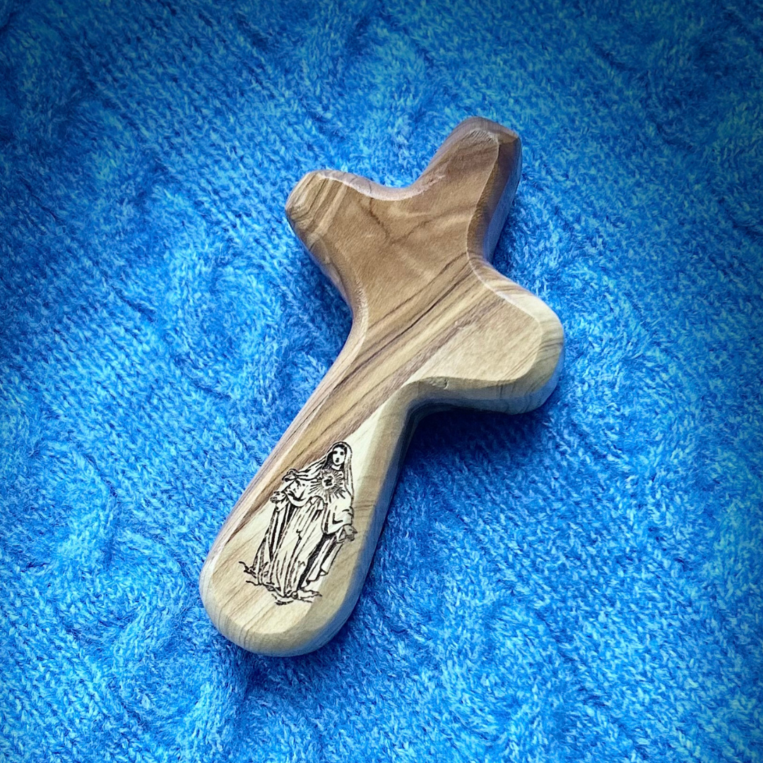 Olive wood holding cross with engraving of the Blessed Virgin Mary on blue blanket