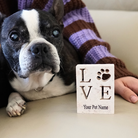 French bulldog and pet owner next to personalized stone plaque with LOVE and a paw print 